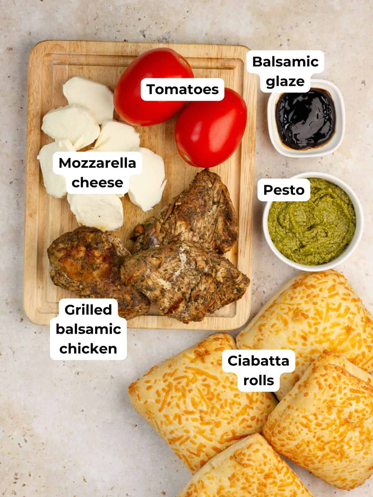 The ingredients for chicken Caprese sandwiches include grilled balsamic chicken, mozzarella cheese, tomatoes, pesto, balsamic glaze, and ciabatta rolls.