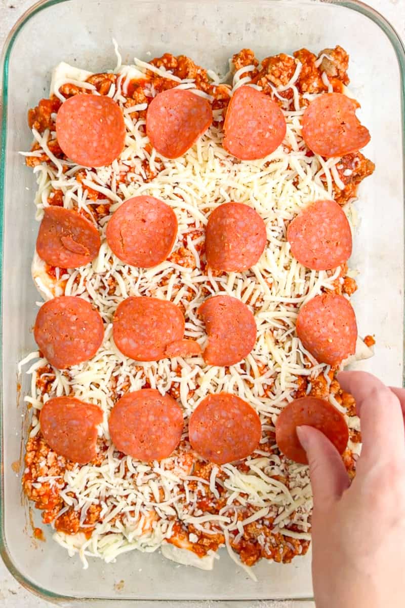 Turkey pepperoni is layered over mozzarella cheese and sauced ground turkey in the biscuit pizza casserole.
48D4F14B-FC1A-42AA-A20F-FE2E2C6926E1: Refrigerated biscuit dough is cut i