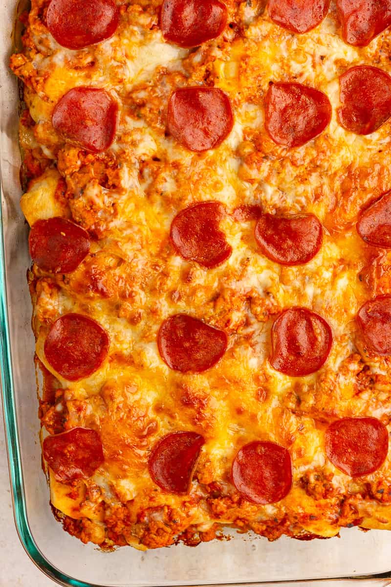 Baked biscuit pizza casserole is topped with melted cheese and turkey pepperoni.