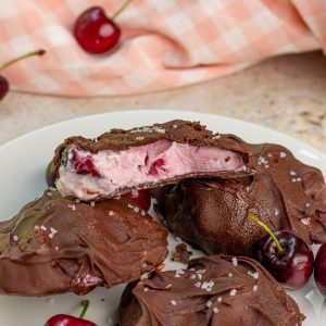 Chocolate covered cherry yogurt bites are topped with flaky salt on a plate.
