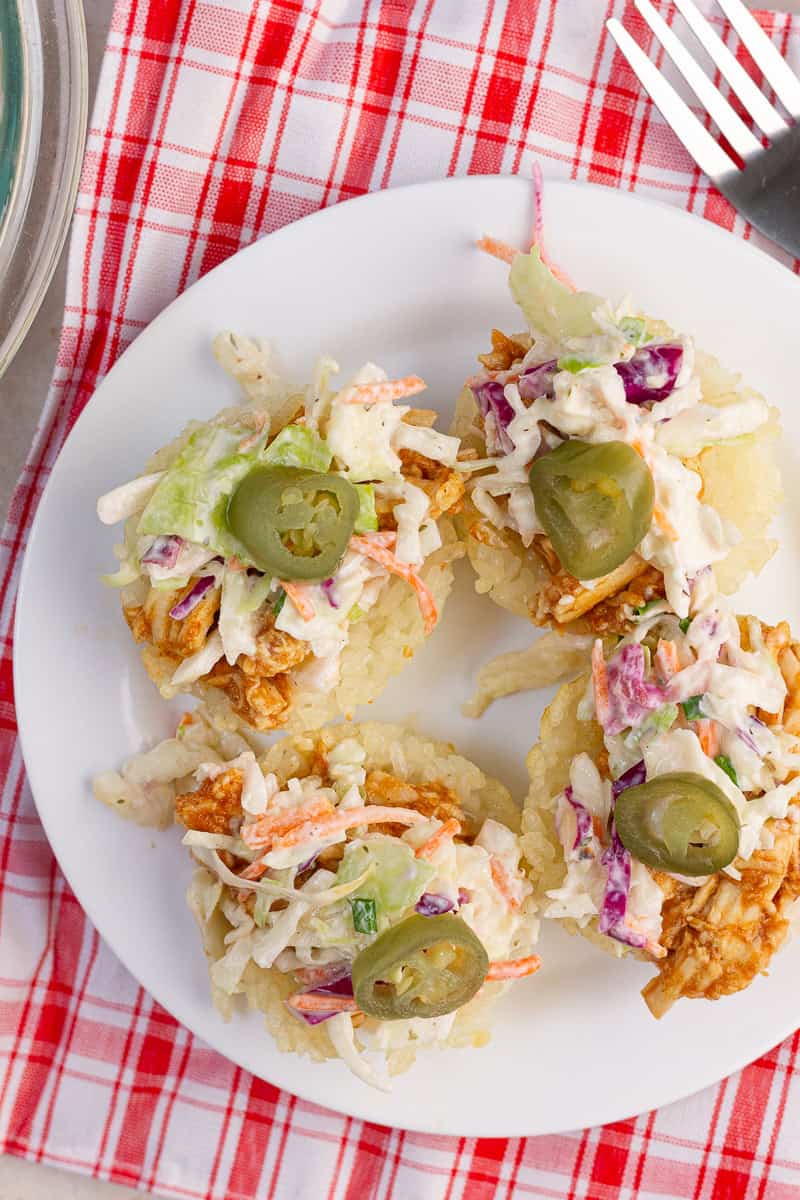 Four BBQ chicken crispy rice cups topped with creamy ranch coleslaw and pickled jalapeños.