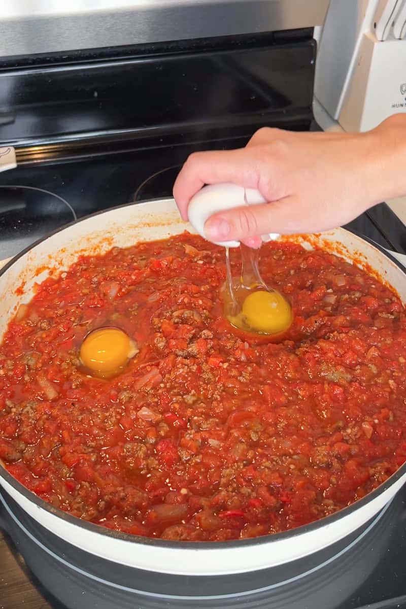 Eggs are cracked into wells in the tomato sausage sauce for high protein shakshuka.