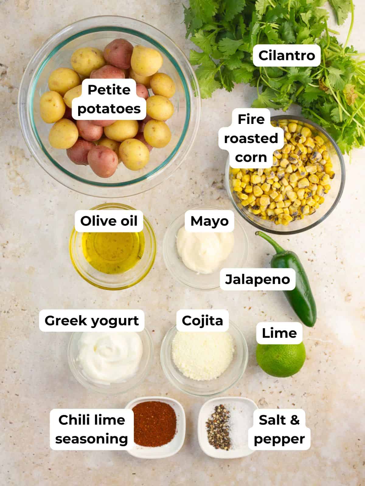 Ingredients for Mexican street corn smashed potatoes are labeled on a light countertop.
