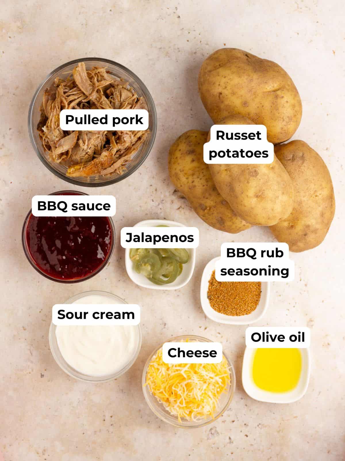 Pulled pork baked potato ingredients are arranged with labels on a light countertop.